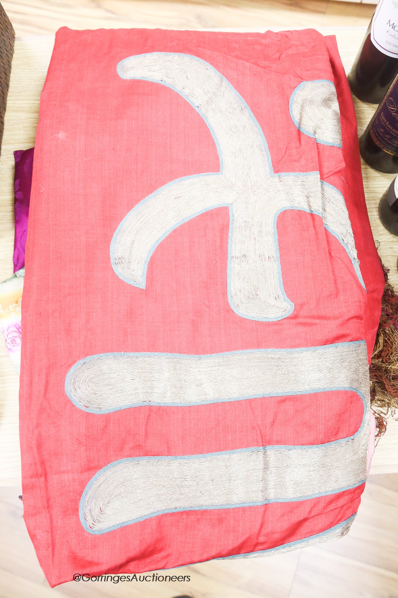 Two Chinese red silk hangings, a mauve damask hanging and a brightly coloured silk panel